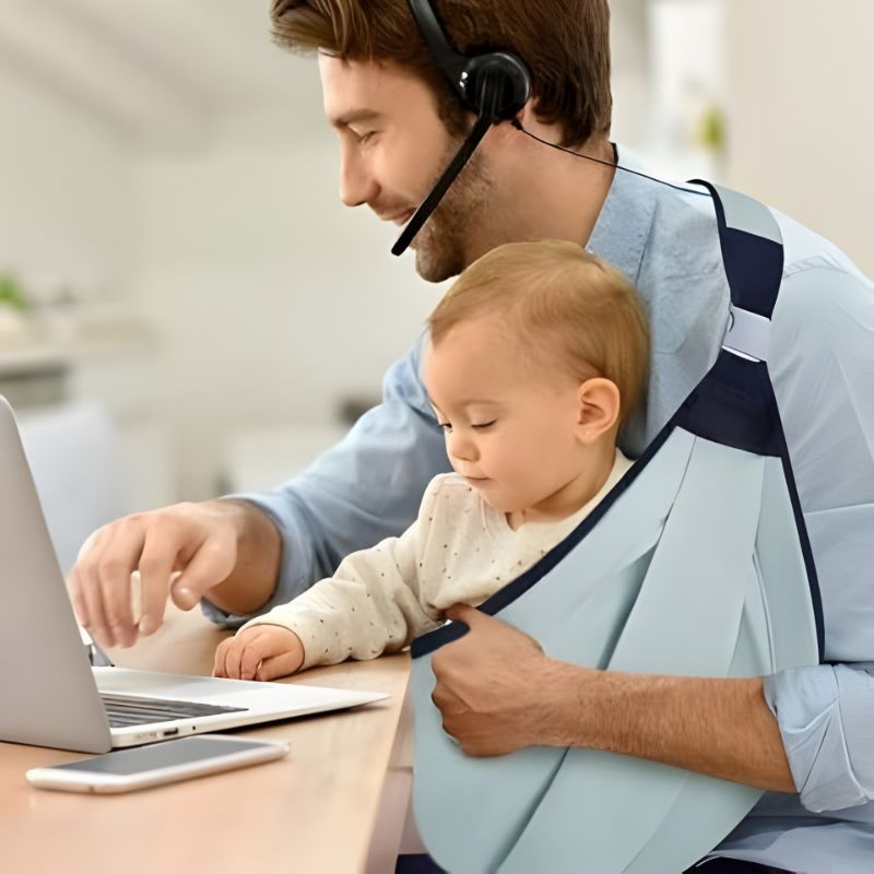 papa travaillant avec son bébé porté dans le porte-bébé naissance Baby Carrying Strap