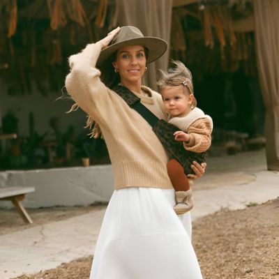 maman en sortie portant son enfant avec le porte bebe léopard
