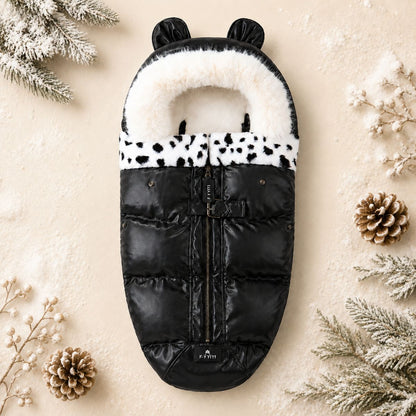 chancelière poussette hiver Cocon Douillet en coloris noir avec intérieur blanc, col en fourrure à motifs noirs et capuche avec oreilles.