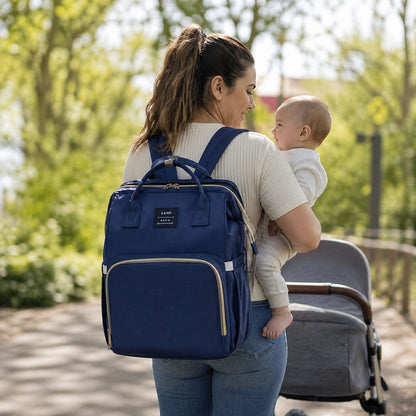 Sac à dos à langer Nid Nomade porté par une maman avec bébé lors d’une sortie en extérieur avec poussette 