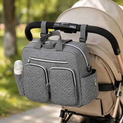 sac à langer Élégance Organisée fixé à une poussette beige pour organiser les indispensables de bébé en déplacement 