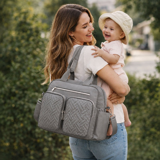 Sac à langer Élégance Organisée porté à l’épaule par une maman avec son bébé lors d’une sortie 