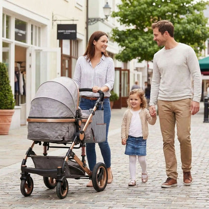 Sac à langer multifonction Pack Sérénité accroché à la poussette lors d’une promenade en ville en famille